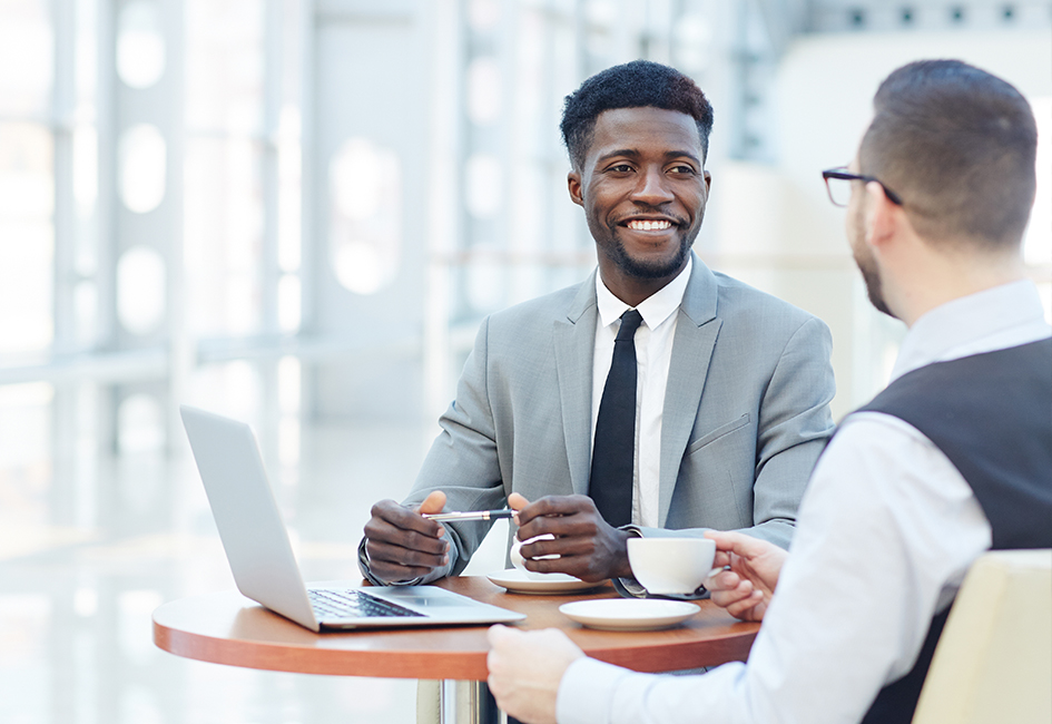 young businessman smiling at coworker