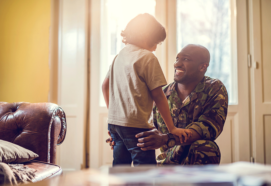 Military father in uniform smiling at young child
