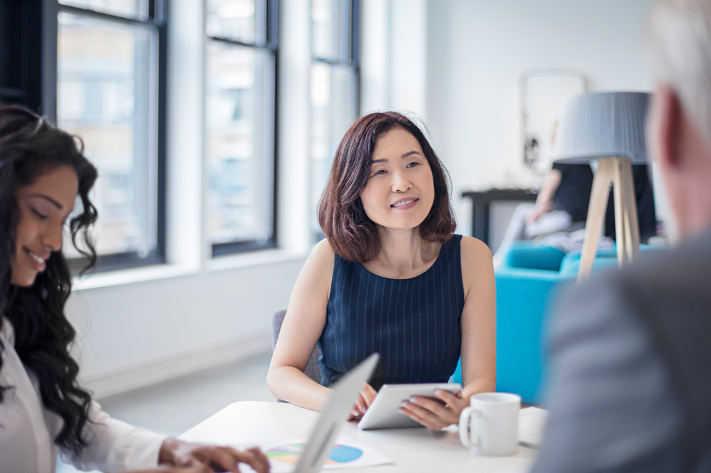 business women smiling at coworker during office meeting