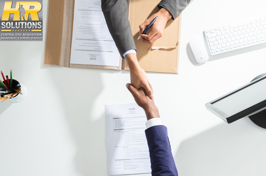 2 business people shaking hands across table