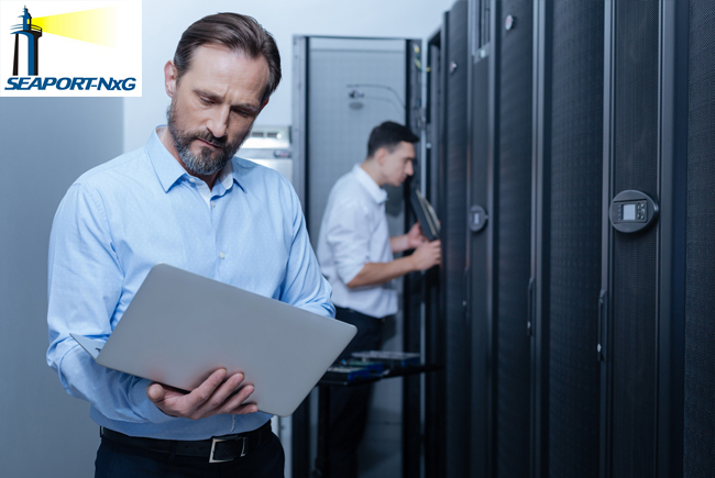 2 businessmen standing by lockers, one looking into locker, other holding and looking at laptop