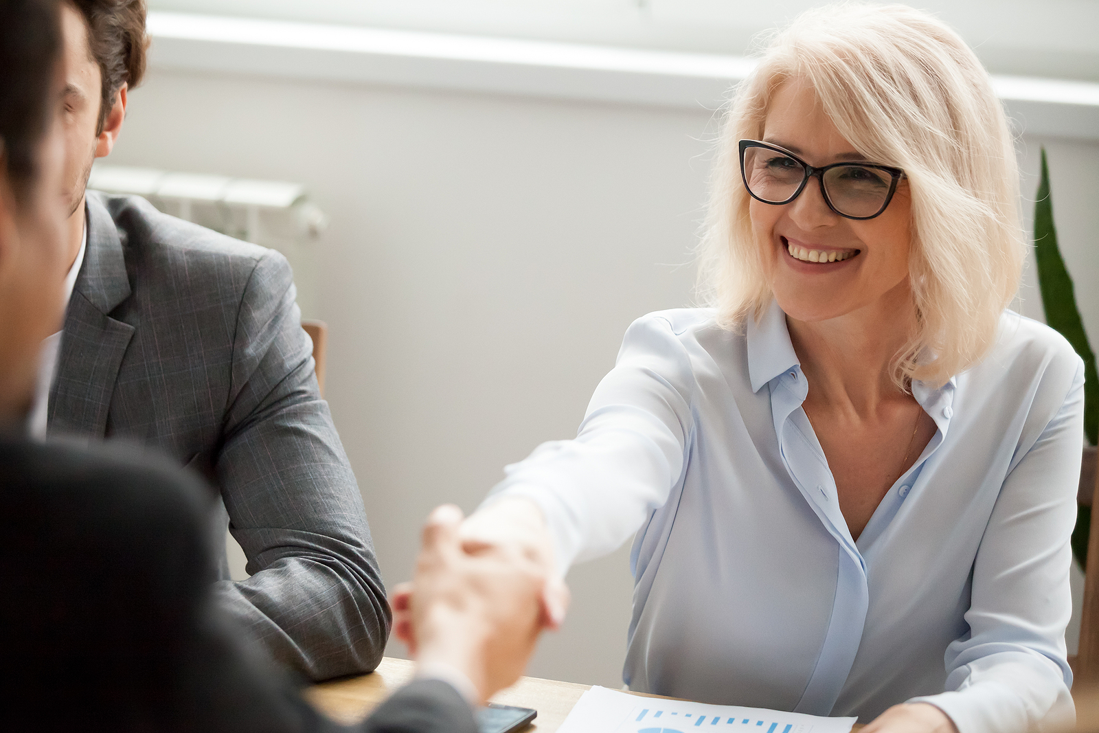 Woman smiling and shaking hands during meeting