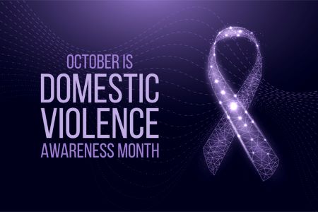 Purple ribbon with sparkles on dark purple background, “October is Domestic Violence Awareness Month".